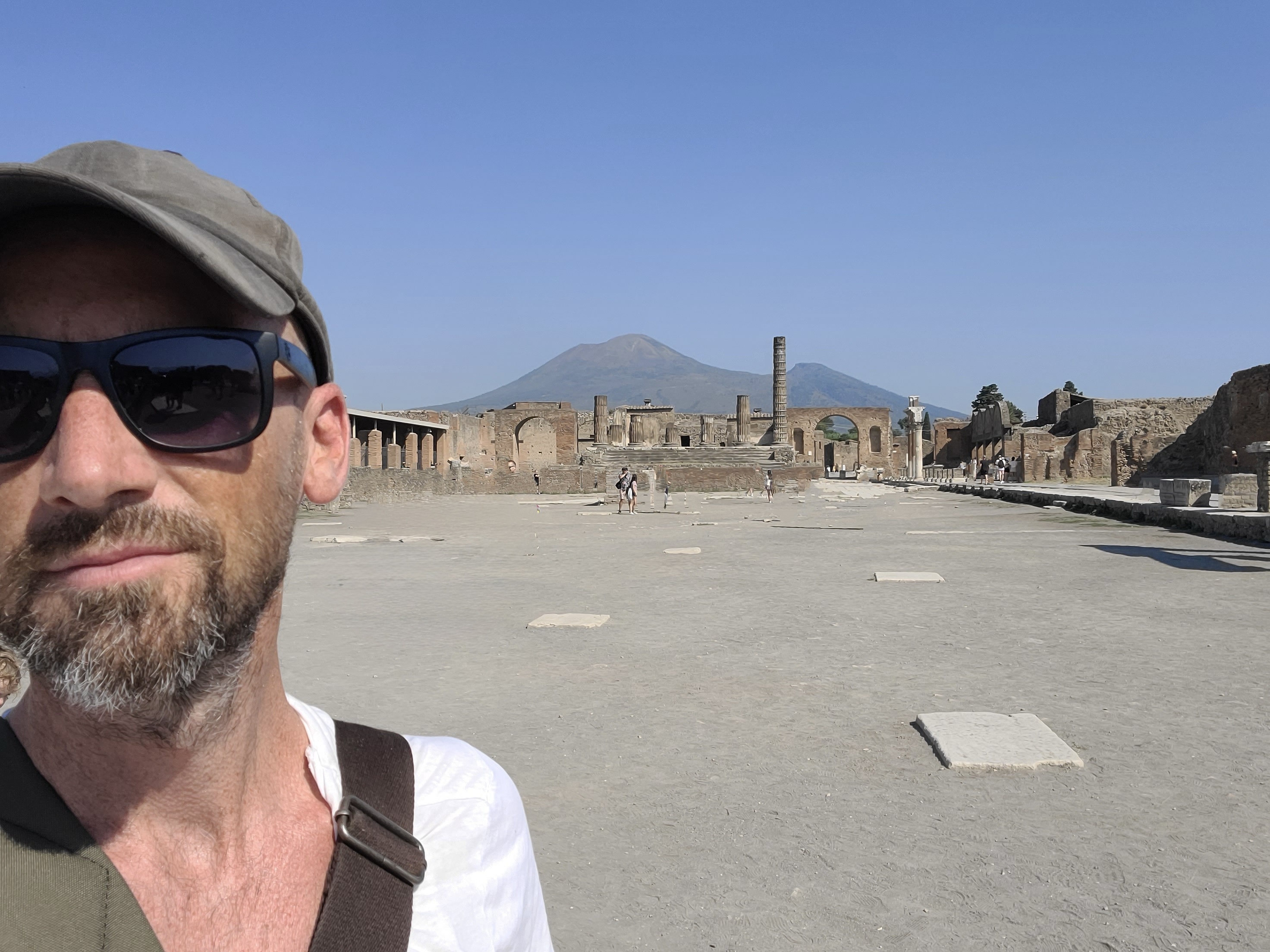 James Kruck standing in Pompeii with Mt. Vesuvius in the background